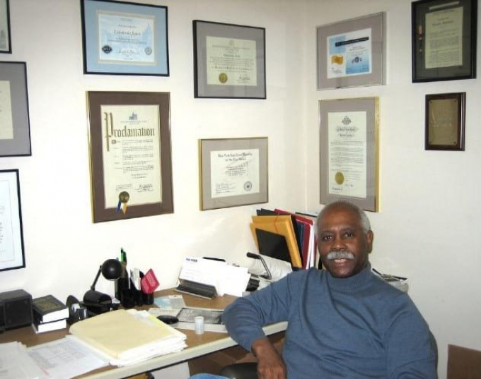 Cal Jones at his desk with framed credentials on two walls