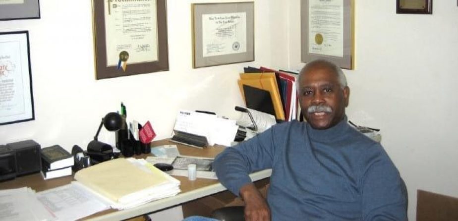 Cal Jones at his desk with framed credentials on two walls