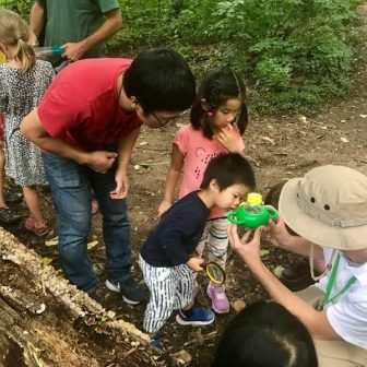 A family closely examines a sample of nature