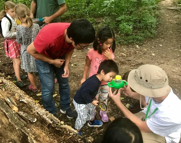 A family closely examines a sample of nature